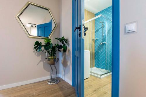 a bathroom with a mirror and a potted plant at Apartament Sun Mare in Gdańsk