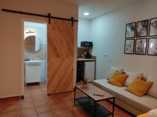 sala de estar con sofá y puerta corredera en ALOJAMIENTO La CAPILLITA HABITACION CON BAÑO, en Sanlúcar de Barrameda