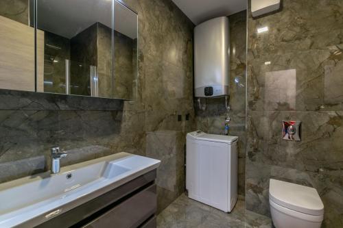 a bathroom with a sink and a toilet and a tub at Empress apartment in Split