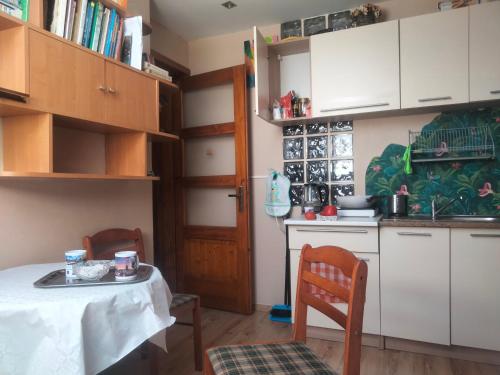 a kitchen with a table and chairs and a kitchen with white cabinets at Dom na Górce in Gorlice