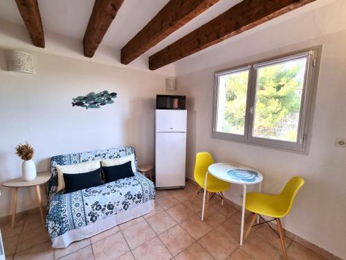 une chambre avec un lit, une table et des chaises dans l'établissement T2 calme proche plage Bonporteau avec Clim et parking, à Cavalaire-sur-Mer