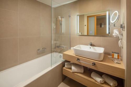 a bathroom with a sink and a shower at Greenfield Hotel Golf & Spa in Bük