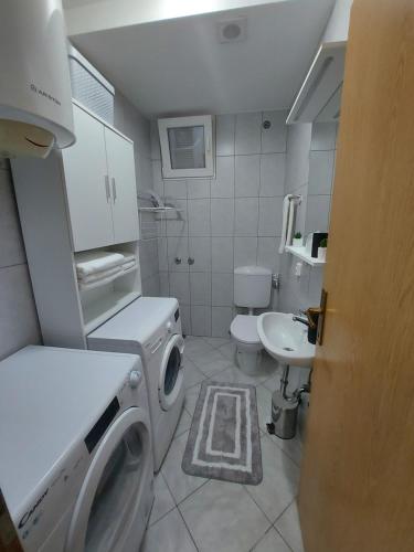 ein Badezimmer mit einer Waschmaschine und einem Waschbecken in der Unterkunft Studio apartment Portofino in Dubrovnik