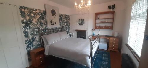a bedroom with a bed and a desk in it at Coastguard Cottage Newquay in Newquay