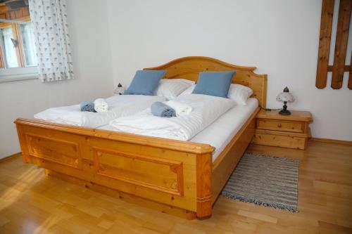 1 cama grande de madera con 2 almohadas azules. en Haus Alexander, en Bischofshofen