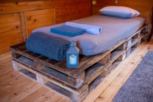a bed on a wooden platform with a candle on it at Marine House Makis in Ledine