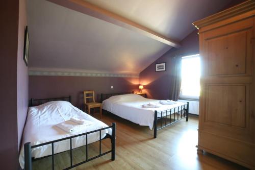 a bedroom with two twin beds and a window at Dolce Casa Pool and Sauna in Francorchamps