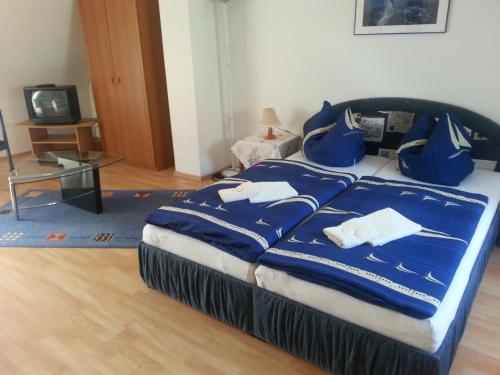 - une chambre avec un lit doté de draps bleus et de serviettes blanches dans l'établissement Pension Am Wassertor, à Wismar