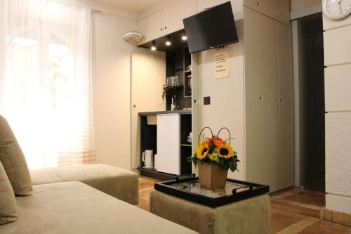 een woonkamer met een vaas met bloemen op een tafel bij Garden Center Apartment in Novi Sad