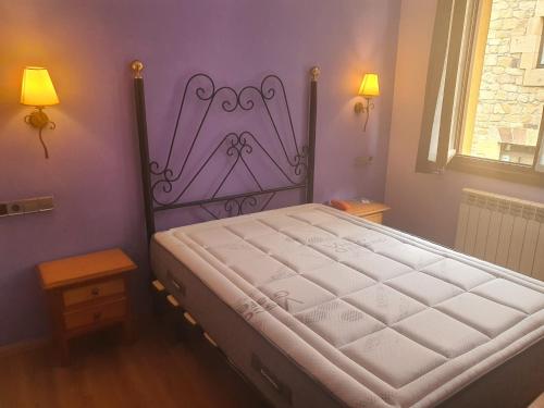 a bedroom with a large bed with a purple headboard at Hotel Virginia R.H. in Vinuesa