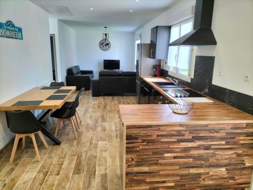 cocina y sala de estar con encimera de madera en Maison plain pied 4 personnes parking gratuit, en Vendeville