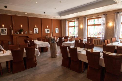 a restaurant with tables and chairs in a room at Hotel Fronhof Mettendorf in Mettendorf