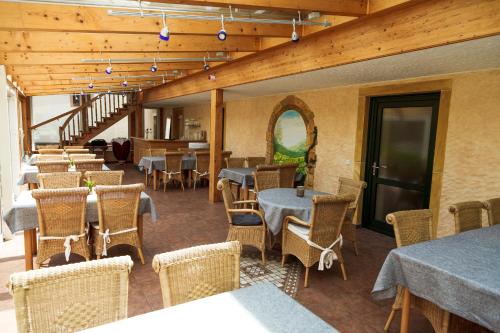 a restaurant with tables and chairs and a staircase at Hotel Fronhof Mettendorf in Mettendorf