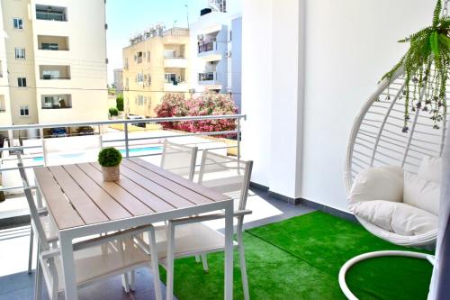 uma varanda com uma mesa e cadeiras e um tapete verde em Stunning Two Bedroom Apartment!! em Lárnaca