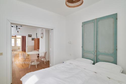 1 dormitorio con 2 camas blancas y mesa en Appartement La Cabane, en De Panne