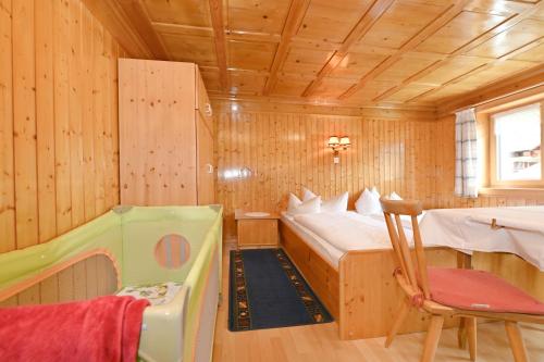 a bedroom with a bed and a crib in a room at Ferienbauernhof Moosbrugger in Schoppernau