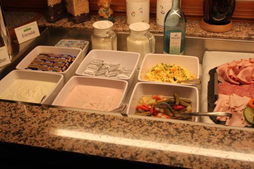 a counter with four trays of food on it at Hotel Sächsischer Hof in Chemnitz