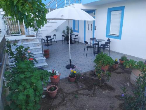 patio ze stołem i parasolem oraz roślinami w obiekcie KANALI HOLIDAYS APARTMENT 1 w Kanalionie