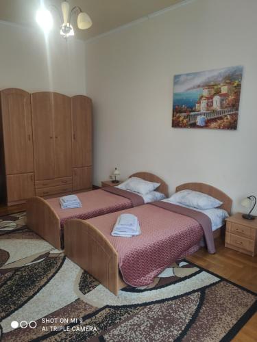 um quarto com duas camas e um quadro na parede em Apartments Domovik ,Kirilla i Mefodiya, 5 em Mukacheve