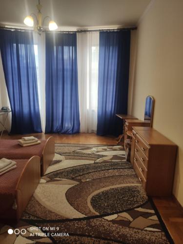 a room with blue curtains and a desk and a table at Apartments Domovik ,Kirilla i Mefodiya, 5 in Mukacheve