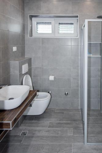 a bathroom with a tub and a toilet and a sink at Apartment Stocic in Rogoznica