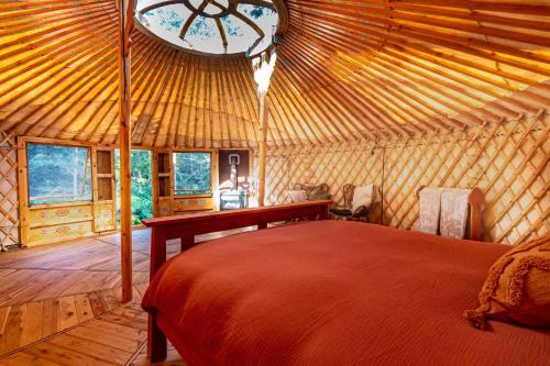 ein Schlafzimmer in einer Jurte mit einem Bett und einer Uhr in der Unterkunft Purling Brook Falls Gwongorella in Springbrook