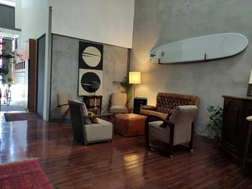 - un salon avec des chaises et une planche de surf sur le mur dans l'établissement Caruma Surf Hostel, à Matosinhos