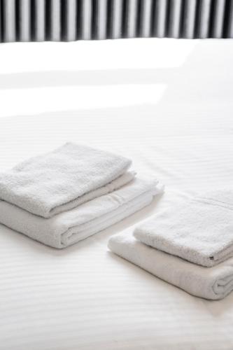 three white towels sitting on top of a table at Ribas Guestrooms in Bruges
