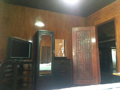 a bedroom with a television and a door with a mirror at SolarCell walking street Homestay - โซล่าเซลล์ถนนคนเดินโฮมสเตย์ in Ban Nong Nam Khan