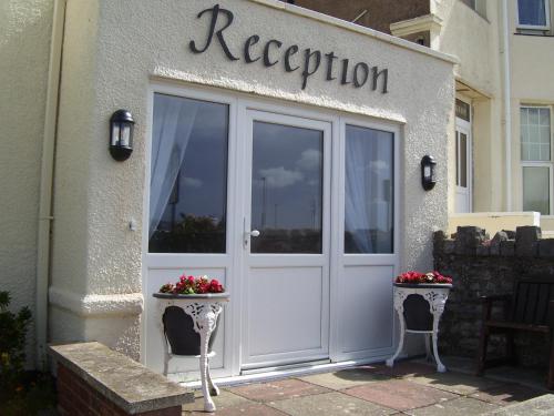 a white door of a store with a sign on it at Plas Gorwelion guest house - Adult only in Llandudno