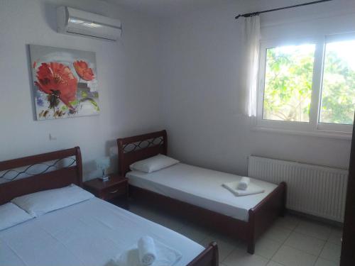 a room with two beds and a window at KANALI HOLIDAYS APARTMENT 2 in Kanali