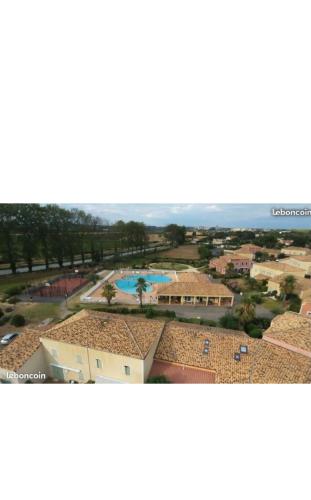 een luchtzicht op een resort met een zwembad bij Villa agréable avec jardin et piscines in Béziers