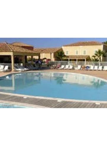 een groot blauw zwembad in een resort bij Villa agréable avec jardin et piscines in Béziers