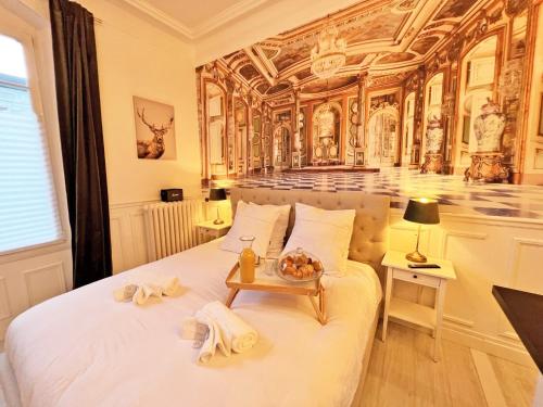 a bedroom with a white bed with a table on it at La Marquise - Cosy Flat - Jacuzzi - Senlis in Senlis