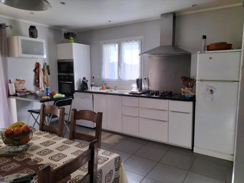 a kitchen with white appliances and a table and a table and a tableablish at Le devezou Malons et Elze in Malons-et-Elze