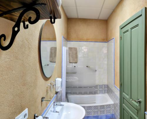 a bathroom with a sink and a tub and a mirror at Hotel Patio de las Cruces in Seville