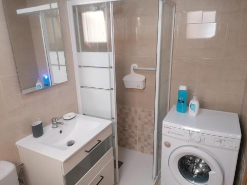 ein Badezimmer mit einer Waschmaschine und einem Waschbecken in der Unterkunft Sea and Relax Apartment By MM in Torrevieja