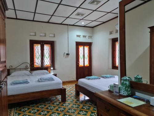 a bedroom with two beds and a mirror at Omah Pitoe Yogya Homestay in Yogyakarta
