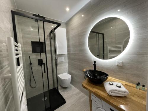 een badkamer met een zwarte wastafel en een spiegel bij Chaleureux studio, 200m de la plage, parking, wifi in Roquebrune-Cap-Martin