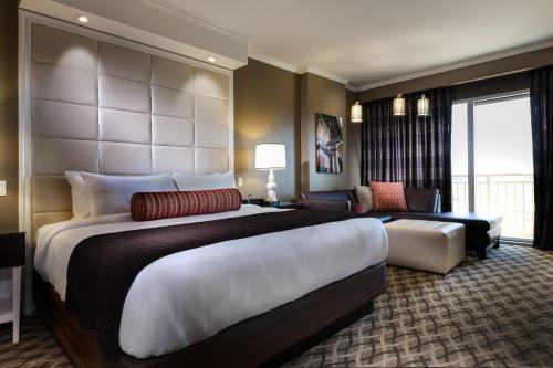 una grande camera da letto con un grande letto e un soggiorno di Golden Nugget Lake Charles a Lake Charles