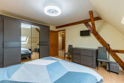 um quarto com uma cama, uma secretária e uma televisão em séjour 6 pers.( atypique ) f4 110 m2 em Houssen