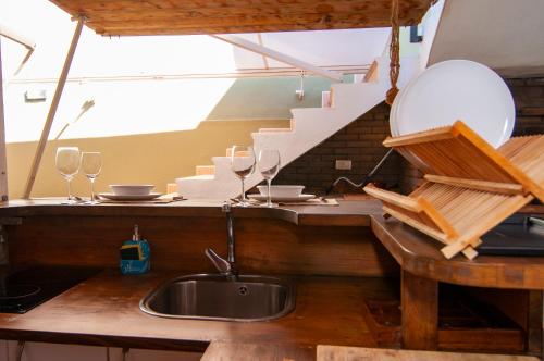 a kitchen with a sink and a counter with wine glasses at Villa Amapola in El Médano