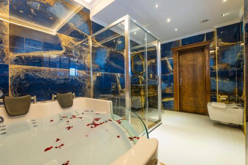 a bathroom with a bath tub and a wall mural at Reis Royal Hotel in Fethiye