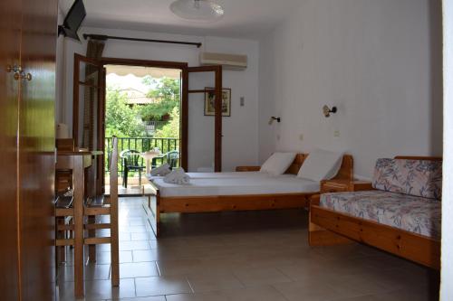 a bedroom with a bed and a couch and a window at Alexander in Pefkochori