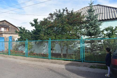a blue fence on the side of a street at Guest House Oimo in Balykchy