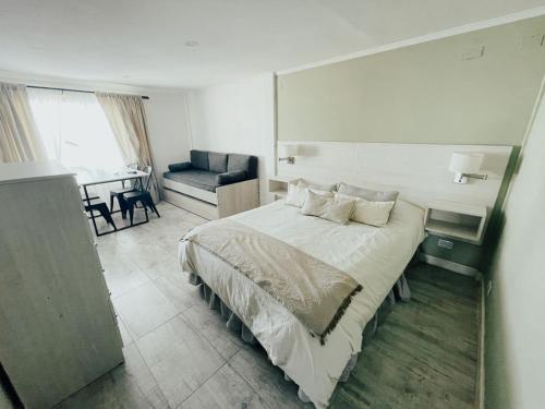 Antu Mahuida Apartments في سان كارلوس دي باريلوتشي: غرفة نوم بسرير واريكة وطاولة