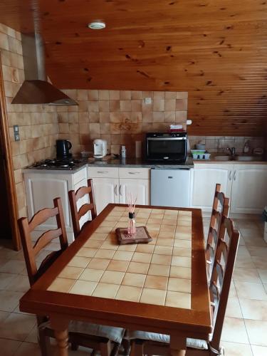 cocina con mesa de madera con sillas y microondas en petite maison de montagne avec jardin, en Cier-de-Luchon