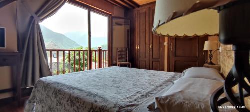 a bedroom with a bed and a large window at Hotelet de Betlan in Betlán
