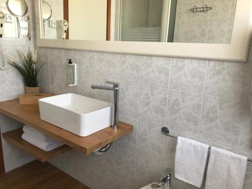 ein Badezimmer mit einem weißen Waschbecken und einem Spiegel in der Unterkunft Golf Hotel in Riccione
