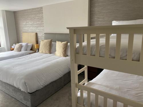a bedroom with two bunk beds with white sheets at The Imperial Garvagh in Garvagh